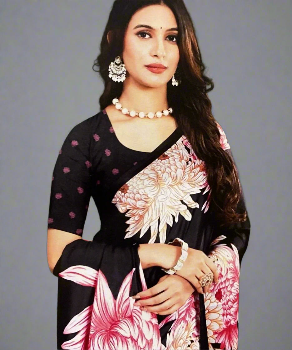 A woman wearing a black saree with pink floral patterns.