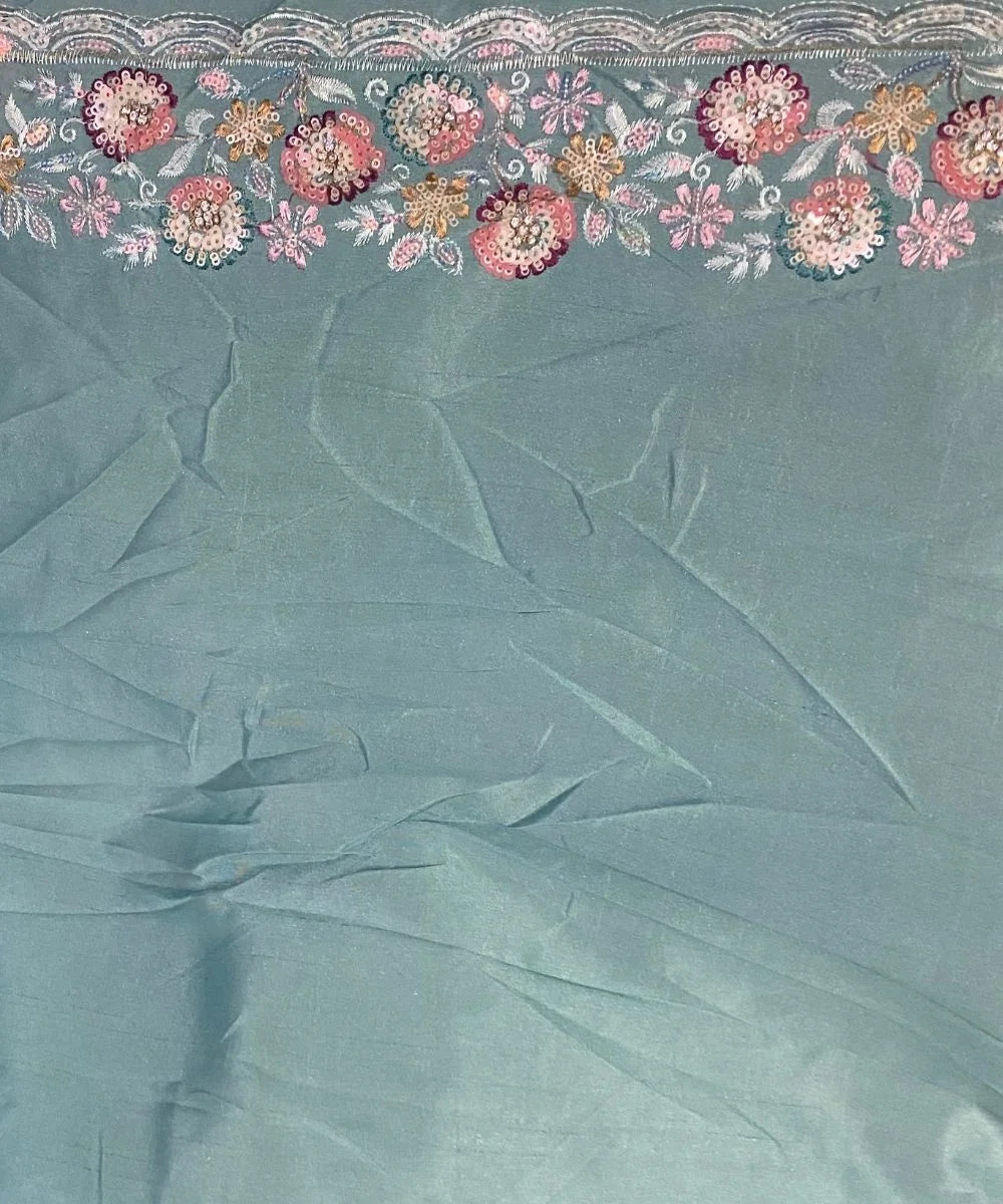 Light blue fabric of blouse with floral embroidery at the top