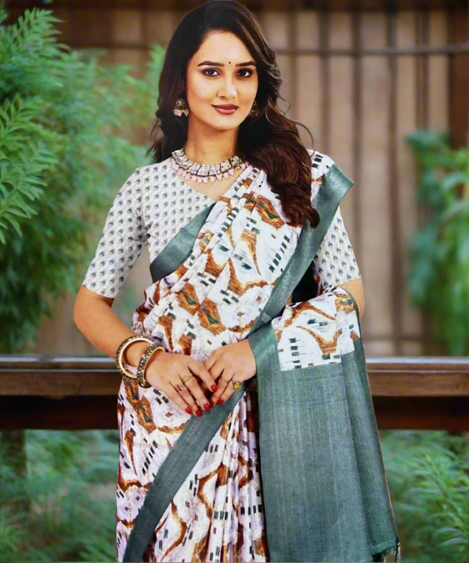 Woman wearing a traditional saree with a patterned blouse against a grey background