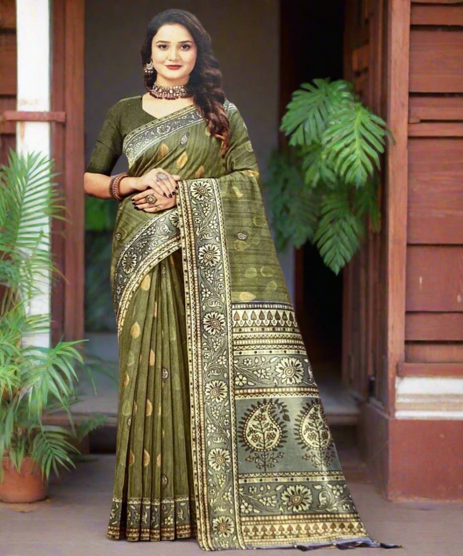 Woman wearing a green saree with a patterned border against a brown background