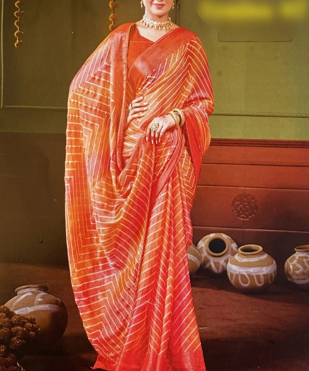 Woman wearing a vibrant orange saree with a traditional setting.