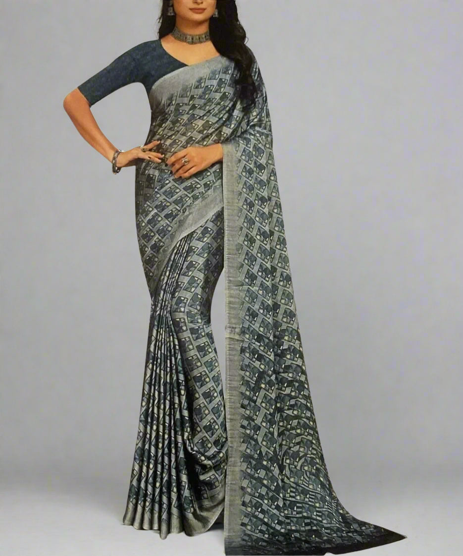 Woman wearing a grey patterned saree on a plain background.
