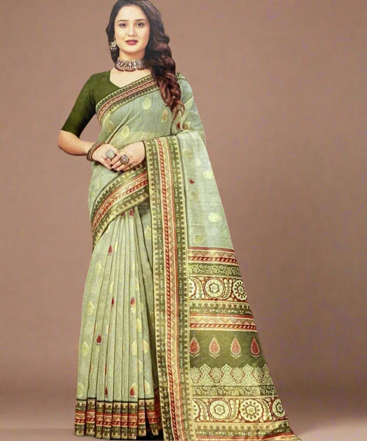 Woman wearing a work wear green saree with a patterned border against a brown background