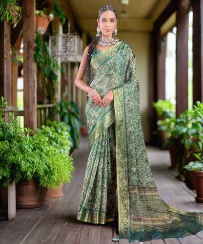 Woman wearing a green saree with a grey background