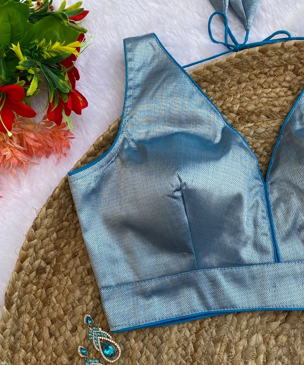 Close-up view of a Sky-blue colored self-printed blouse with a deep V-neck and sleeveless design perfect for a silk saree.