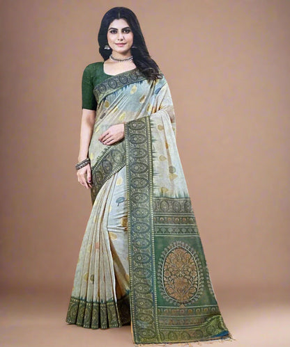 Woman wearing a traditional saree with a green and beige pattern on a brown background