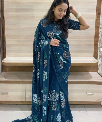 Woman wearing a blue floral saree in an indoor setting