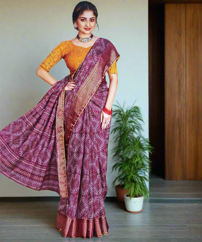 Woman wearing a wine saree with a contast yellow colored blouse.
