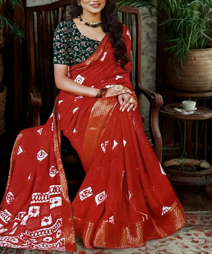 Woman wearing a red saree with white patterns indoors