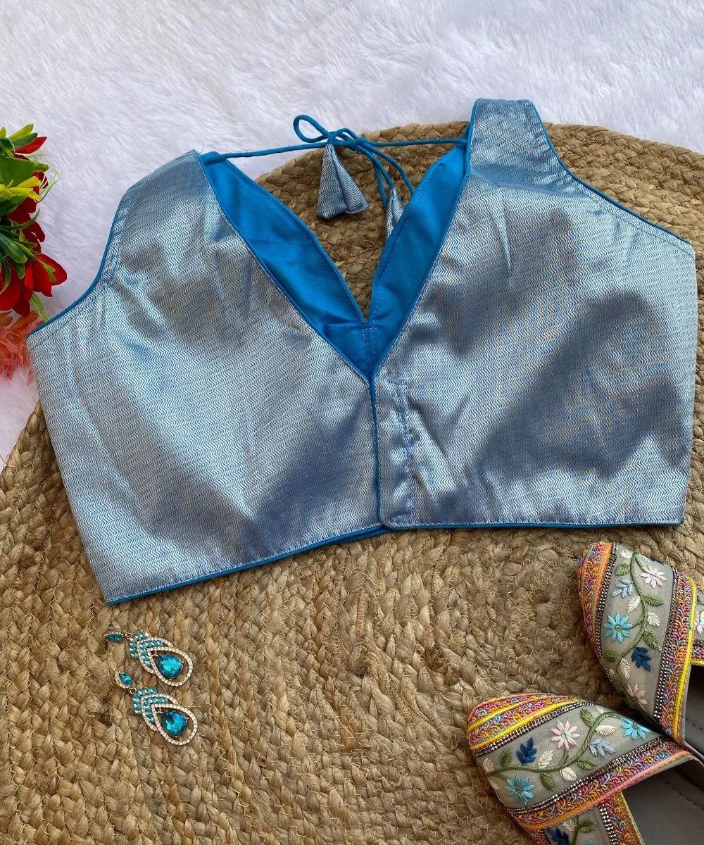 Sky-blue colored self-designed blouse with a deep V-neck and comes with matching sleeves.