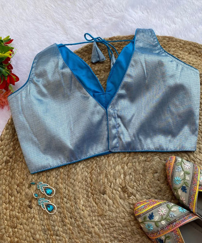 Sky-blue colored self-designed blouse with a deep V-neck and comes with matching sleeves.
