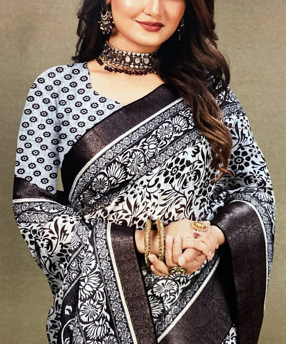 Woman wearing a black and white patterned saree with jewelry on a beige background