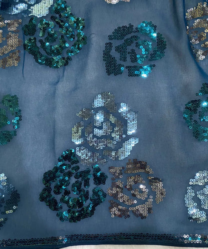 Close-up of sequined fabric with floral patterns .