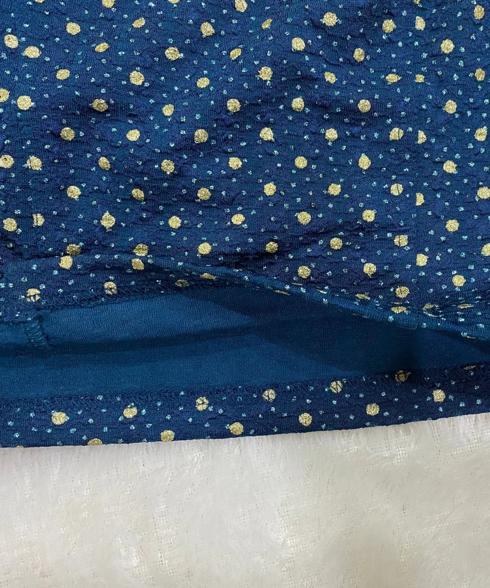 close-up of cotton stretchable blouse with gold polka dots.
