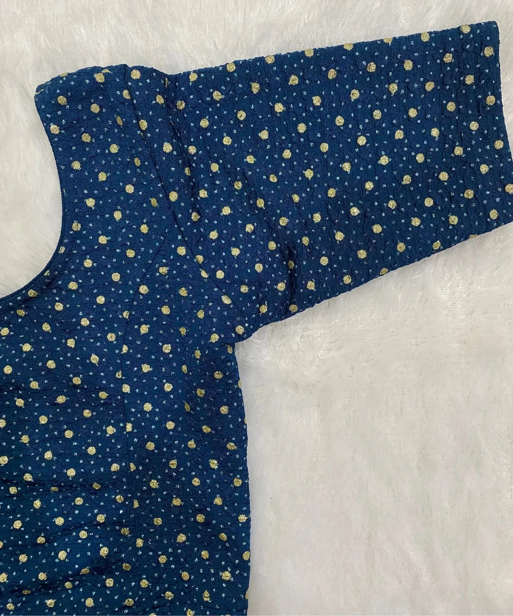 Blue stretchable blouse with gold polka dots on a white background