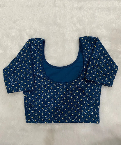 Blue stretchable blouse with gold polka dots on a white background