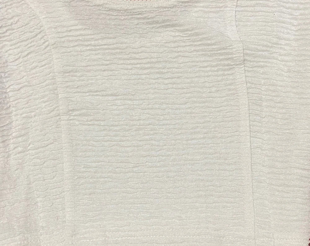 Close-up of a textured blouse pattern on a beige background