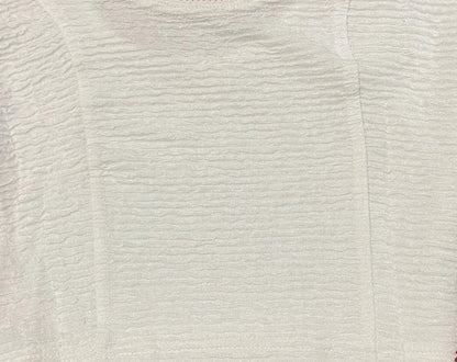 Close-up of a textured blouse pattern on a beige background